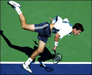 Tim Henman serves to Roger Federer