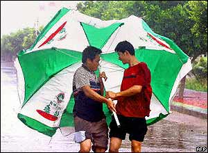 Two men wrestle with umbrellas in China's Yangjiang province