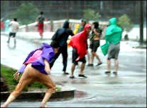 People struggle their way against the strong wind in Wenling, east China's Zhejiang Province August 12, 2004. (Xinhua photo)