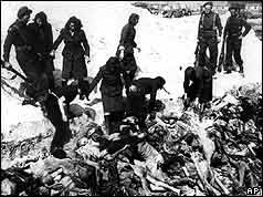 German SS women moving dead bodies into grave 