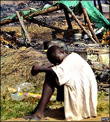 Lone man at the sight of a burned down shelter.