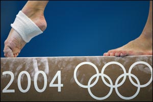 A competitor competes on the balance beam in the qualification round of the team event at the women's artistic gymnastics competition