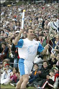 Greek javelin star Costas Gatzioudis runs with the torch