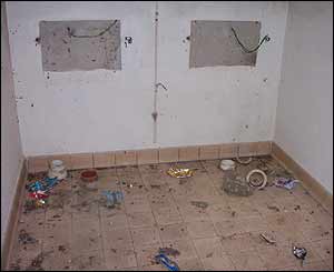 Rubble and a disused toilet seat on the floor of the ladies' side of the toilet block