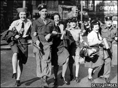 WAAFs link arms with soldiers during the VJ Day celebrations in Piccadilly Circus