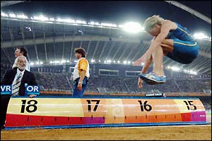 Christian Olsson finishes ahead of Romania's Marian Oprea who took silver and bronze medallist Danila Burkenya of Russia