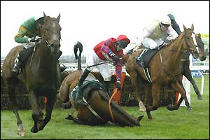 Puck Out, ridden Mark Walsh, clears the last hurdle as Demi Beau falls, before going on to win the Martell Cordon Bleu Handicap Hurdle