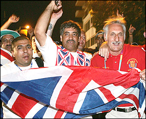 Khan's father Shajaad (centre) leads the celebrations after his son's passage into the lightweight final