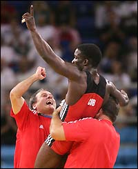 Cuba's Yandro Miguel Quintana celebrates with his coaches after beating Iran's Masuod Jokar of Iran to win gold in the men's 60kg wrestling