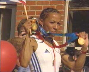 Holmes, wearing both medals, looked proud and overjoyed as she waved back at fans from the bus.