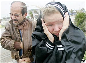 A father and daughter brace themselves against high winds in Indialantic Beach, Florida