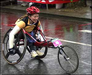 A happy-looking wheelchair competitor makes her way along the Thames