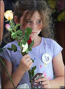 Girl holds a flower during ceremonies at Ground Zero