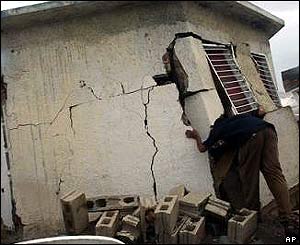 Jamaican man examines his damaged house in Kingston, Jamaica