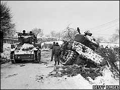 US tanks, one in a ditch, other passing on road