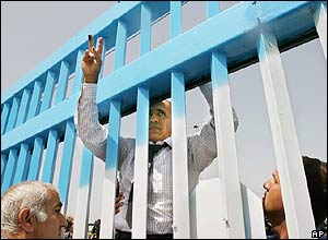 Mordechai Vanunu climbs the gates outside his former prison