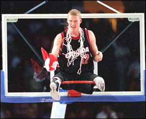 Patrick Anderson of Canada sits on the hoops in celebration 