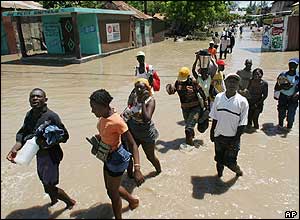 People leave their homes during floods in Haiti