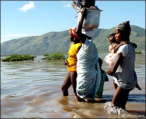 Haitian women wade through water in Gonaives.
