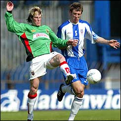 Glens striker Andy Smith and Gareth McAuley tussle for the ball