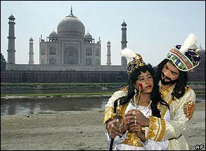 Actors dressed as the Mughal Emperor Shah Jahan and his wife Mumtaz Mahal stand in front of the Taj Mahal