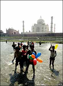 Indian children carry the balloons released during the inauguration ceremony to mark the 350th Anniversary of the Taj Mahal on the banks of Yamuna river in Agra.