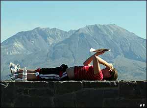 Kim Latschaw, of Gig Harbor, Washington, reads a newspapers as she awaits an eruption from Mount St Helens, 3 October 2004
