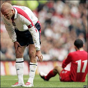 David Beckham holds his leg after a tackle with Ryan Giggs