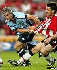 The Welsh boss Mark Hughes gets stuck in against Southampton's David Prutton