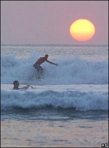 Surfers catch the waves at sunset, Saturday, 9 October 2004