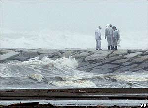 Local police investigate as they are reported a missing man as a powerful typhoon is approaching to the eastern Japan in Kujukuri, Japan, Wednesday, Oct 20, 2004