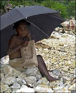 Boy shelters under umbrella in Fonds Verettes, Haiti
