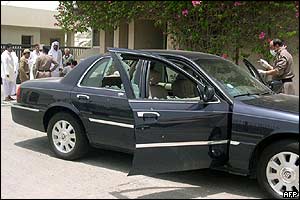 Policeman inspects car at site of one of the attacks
