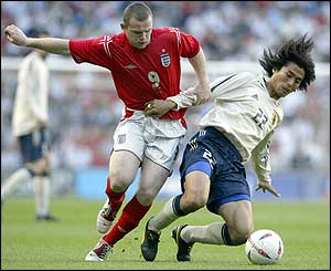 England's Wayne Rooney shrugs off the challenge of Yuji Nakazawa 