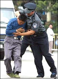 A Chinese policeman grabs a protester in Beijing's Tiananmen Square, June 4, 2004 