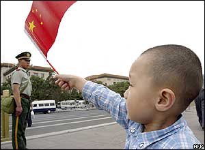 A young Chinese boy waves the national flag during a visit to Tiananmen Square in Beijing 04 June 2004