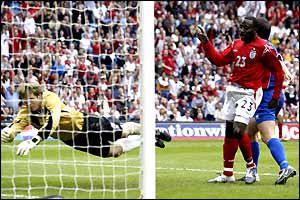 Darius Vassell celebrates as Arni Arason can't keep the ball out