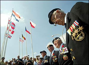 Fifteen D-Day veterans from the Royal Navy Tank Landing Craft pray for their colleagues in the square in Arromanches