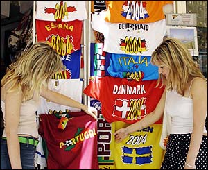 Tourists look at T-shirts as the 16 nations get ready to compete in the big tournament