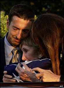Nancy Reagan is embraced by her children, Ron (left) and Patti (right) after the internment service
