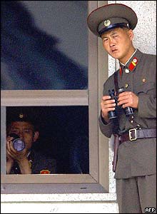 North Korean soldiers look to the south side on the border village of Panmunjom, north of Seoul, 16 June 2004. 