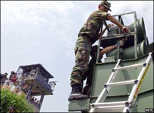 South Korean soldier take down a battery of propaganda loudspeakers along the border with North Korea in Paju , 16 June 2004