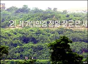 A propaganda slogan praising North Korean leader Kim Jong-il is on display at the border town of Panmunjom, 16 June 2004 