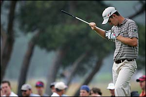 Justin Rose inspects his club at the fourth