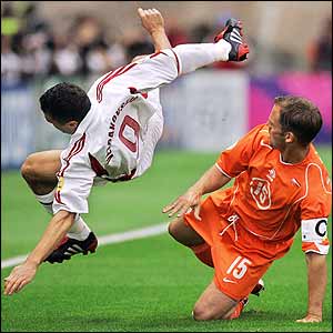 Latvian forward Maris Verpakovskis is upended by Dutch defender and captain Frank de Boer