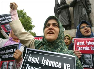 Protesters carry signs reading 