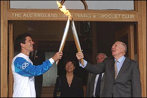 Sir Roger Bannister passes the flame to Tim Henman 