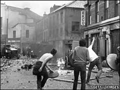 Rioters throwing missiles towards armoured car