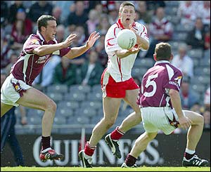Joe Bergin of Galway moves in to challenge Tyrone midfielder powerhouse Sean Cavanagh