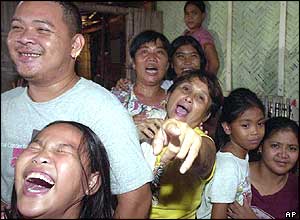 Relatives and friends of Filipino hostage Angelo de la Cruz react as they see him on television after his release (July 20, 2004)